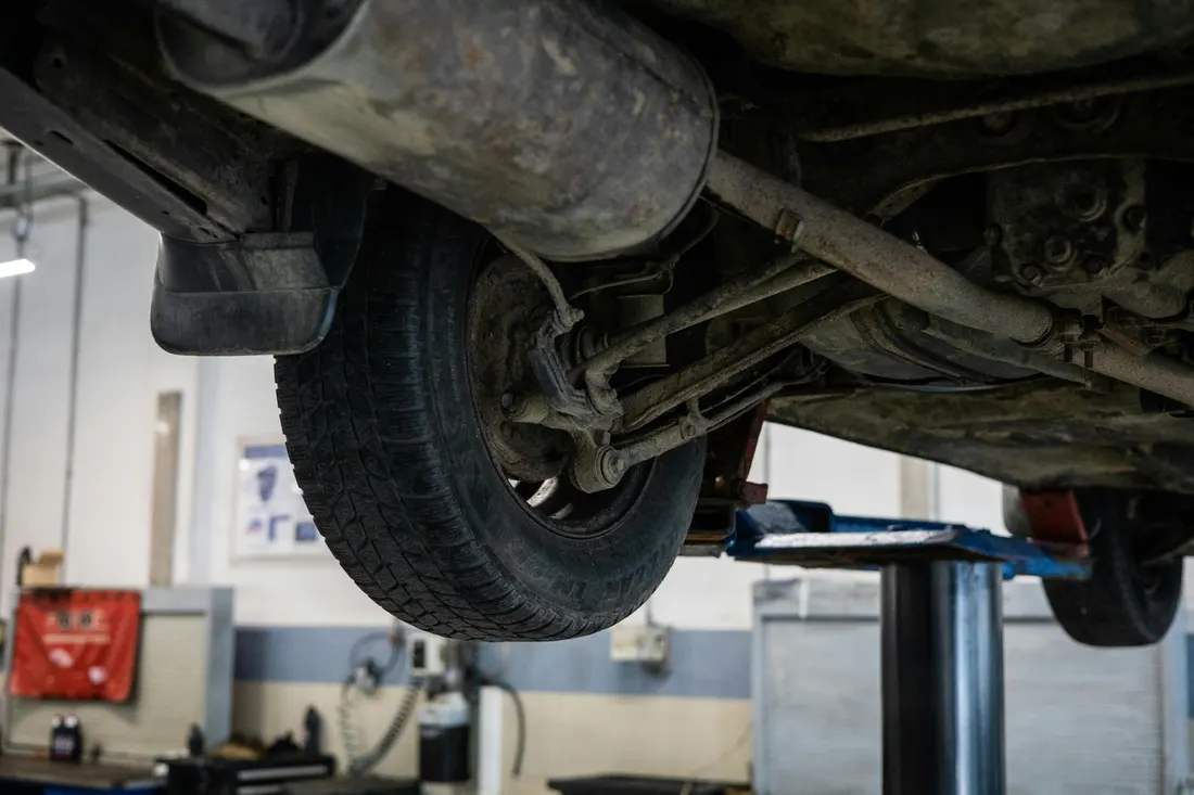 Exhaust system repair — underside of a vehicle raised on a service lift